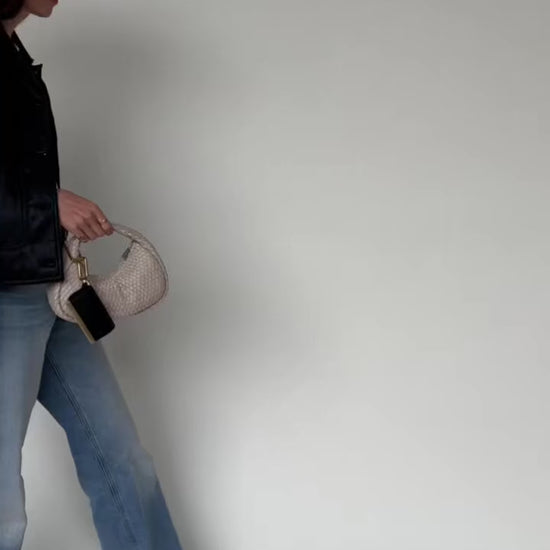 Woman walking while carrying the folded Olniy pouch by its strap