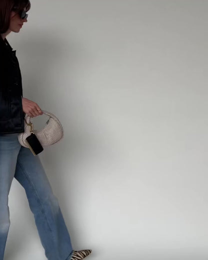 Woman walking while carrying the folded Olniy pouch by its strap