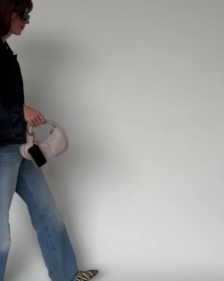 Woman walking while carrying the folded Olniy pouch by its strap